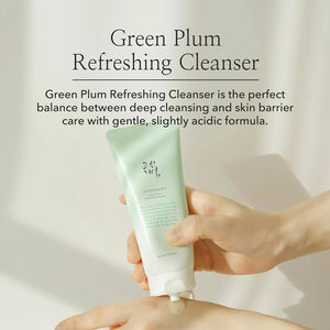 Hand holding a tube of Green Plum Refreshing Cleanser, gentle deep cleansing skincare